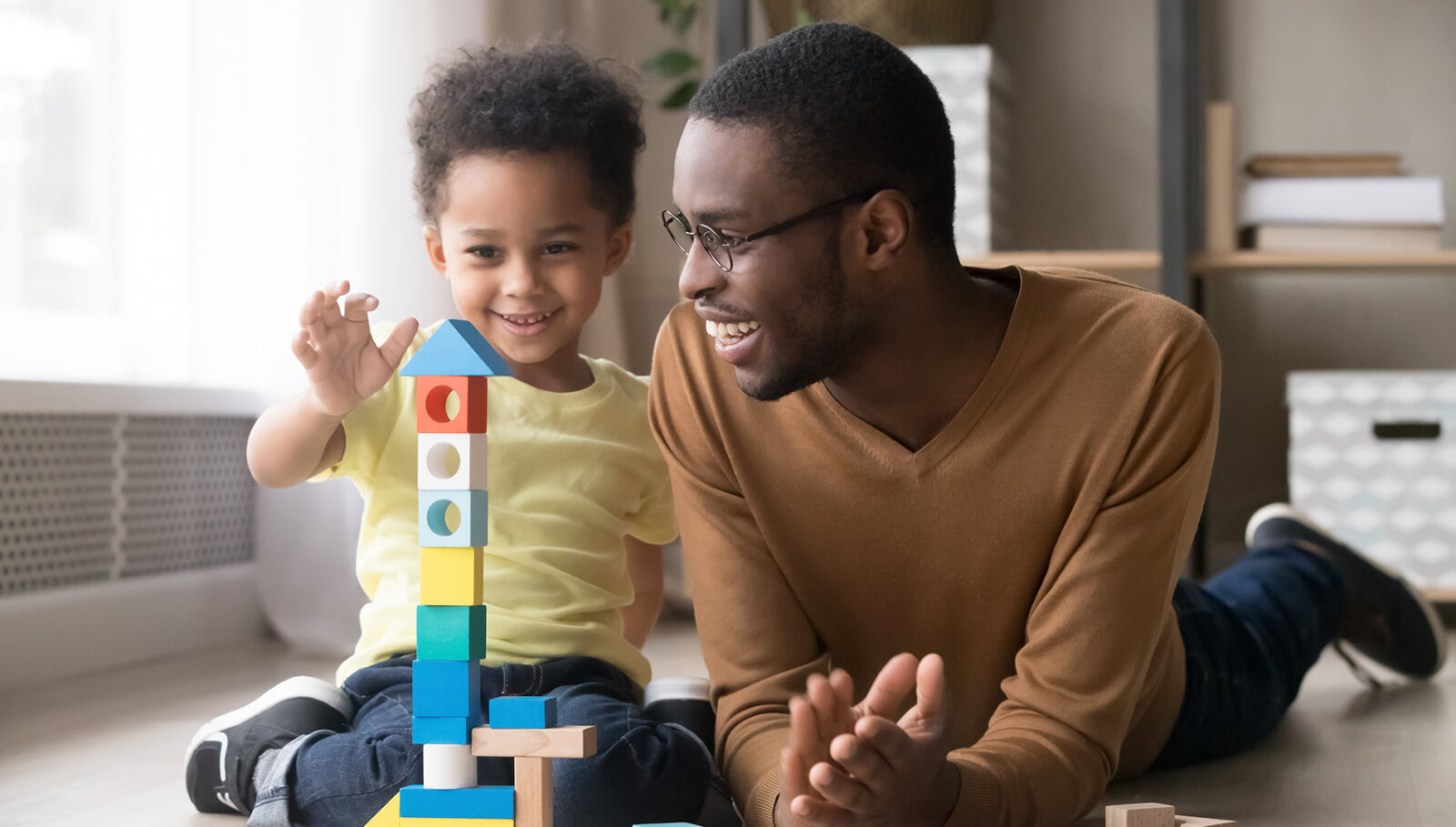 man and young child playing with blocks