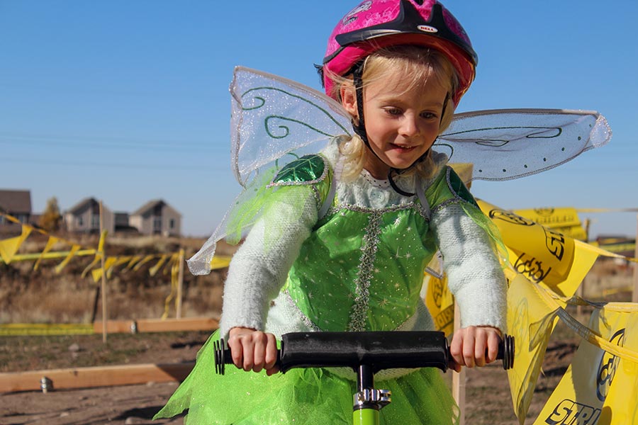 girl wearing a fairy costume and riding a bike