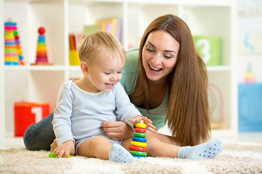 woman playing with baby on floor
